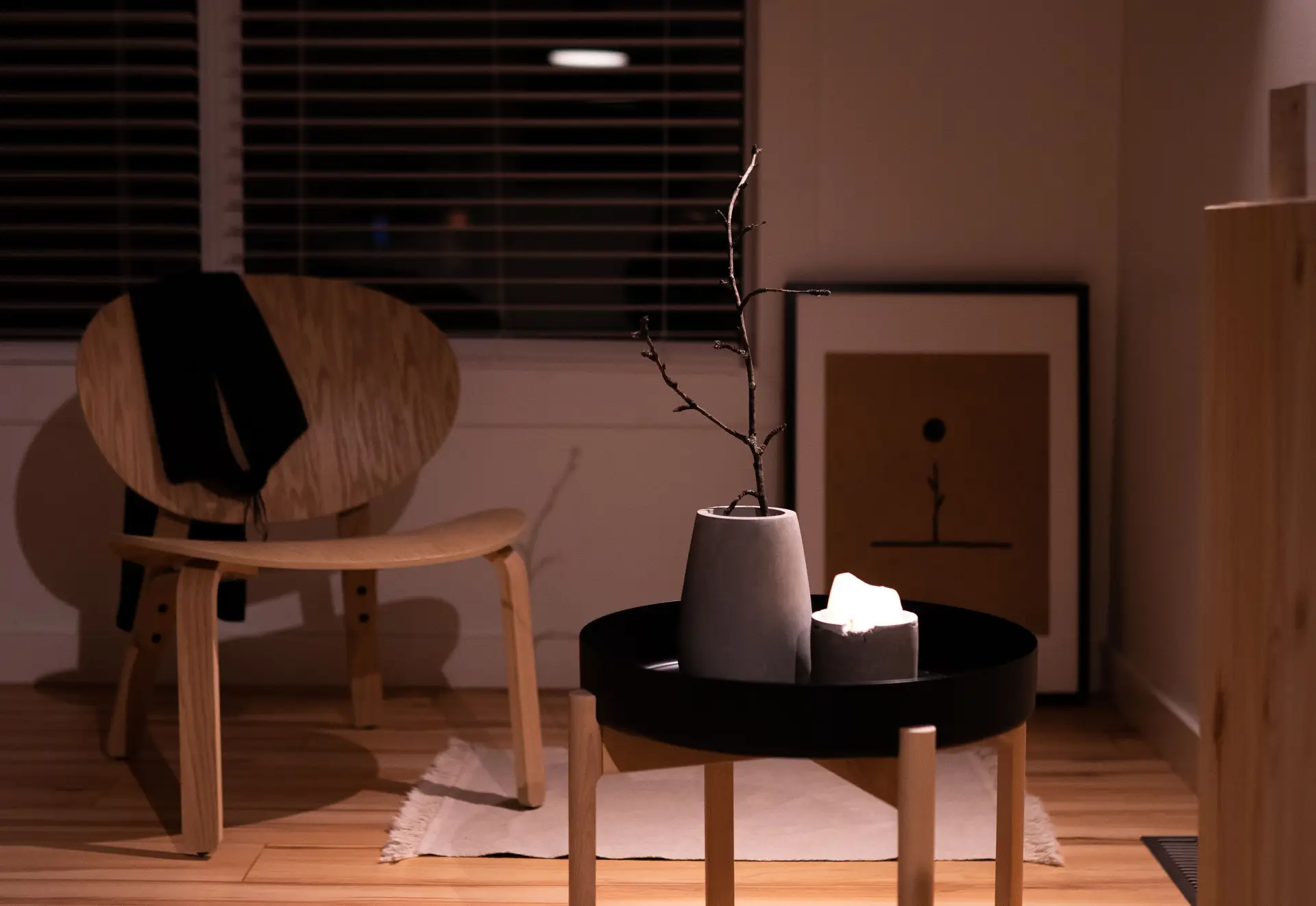 Minimalistinen nojatuoli ja puinen sohvapöytä lämpimässä valossa